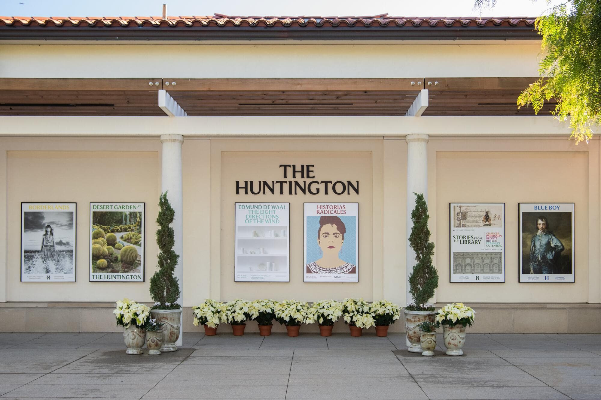 A wall with posters of various exhibitions and the words "The Huntington" above them.