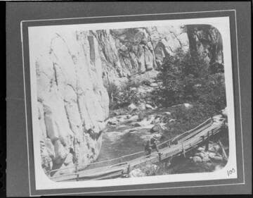 A man standing on a foot bridge across the Santa Ana River