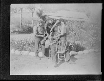 Three men pretending to shave another man with a machete at Mill Creek #1 Hydro Plant