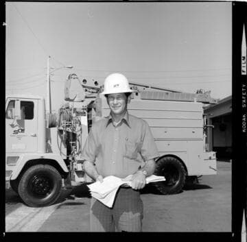 Lineman or Foreman by his truck with project paperwork and plans