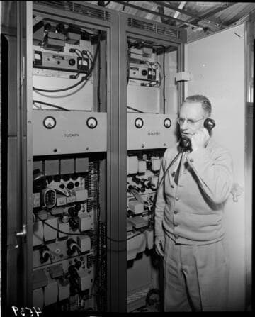 Man on phone at back of switchgear panel