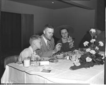 Family at luncheon after meter installation?  Father is holding a Gold Medalion home coin
