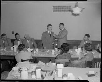 Man being pinned with service pin at luncheon
