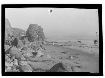 Castle Rock along highway with people fishing on the beach, Santa Monica