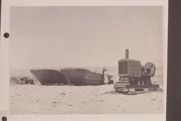 Barges at the rim prepared to be lowered to the Marble Canyon dam site at 39 where they were used as a platform for the drilling.  Margaret Marston talks with one of the crew
