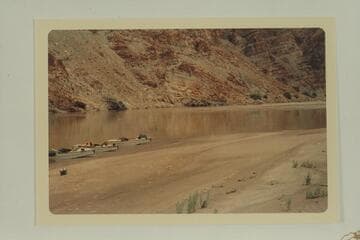 Mile 206.85 in Cataract Canyon with Stavely's boats on the beach opposite the A. G. Turner inscription