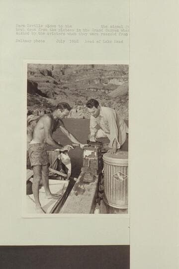 Norm Nevills shows to the [blank] the signal gun and radio brought down from the plateau in the Grand Canyon where they had been cached by the aviators when they were rescued from there in 1944.  Head of Lake Mead
