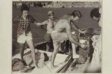 Nevills unloads the radio set which was recovered from the plateau below Point Sublime.  John Doerr and Nancy Streator are back of him.  The set was dropped to the 3 aviation men in 1944 when they parachuted into the Canyon