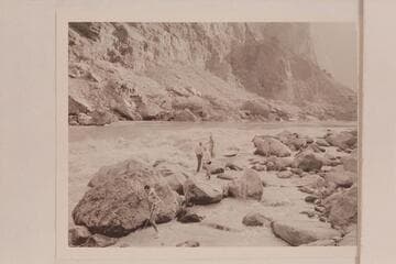 Lining of the Nevills skiffs at Lava Falls.  Garth Marston is taking the stern line down at the left.  John Riffey and Randall Henderson stand on the rocks taking instructions from Nevills.  Kent Frost stands among the rocks at the right