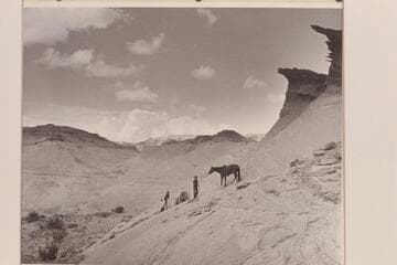 Down the slickrock from the mesa in front of Arch in the Sky at the edge of Navajo Canyon, Arizona.  Left to right:  Tom Daly; Buck White-hat; Bahe