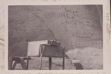 Autographs and dates on wall of cave.  The name Bert Loper is cut in the sandstone