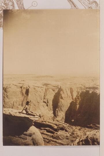 LaRue sitting on rim looking at Lees Ferry dam site at Mile 4 1/2