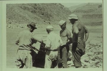 Repairs to the "Grand" after Freeman had rammed the shore in Diamond Creek Rapid.  Left to right:  Burchard; Kolb; Lint; and Freeman.  Freeman enjoyed featuring decrepit clothing