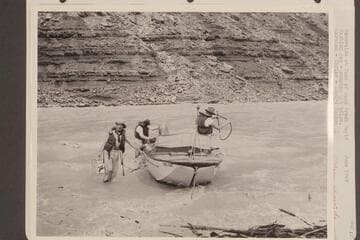 "Esmeralda" at foot of Soap Creek Rapid.  Caching gas, pumping the bilge.  Marston; Taylor; Edward Hudson.  Stage 65,000 -+ cfs