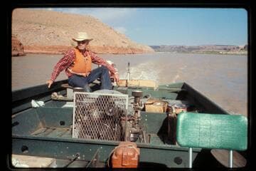 Joe Lyon in stern of his boat, San Juan River
