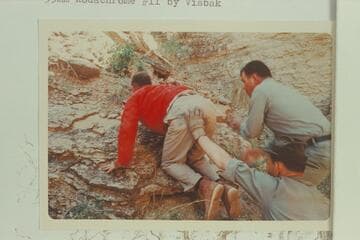 Helping Butchart out of Royal Arch Creek to the top of Royal Arch where the helicopter had landed