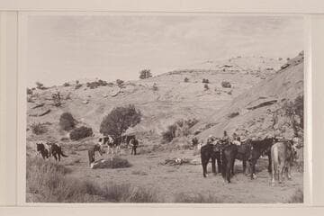 Camp the first night in Navajo Canyon.  Bill Belknap at left.  Jorgen Visbak ties on his saddle bags.  Buck White-hat watches Nancy Daly in the background