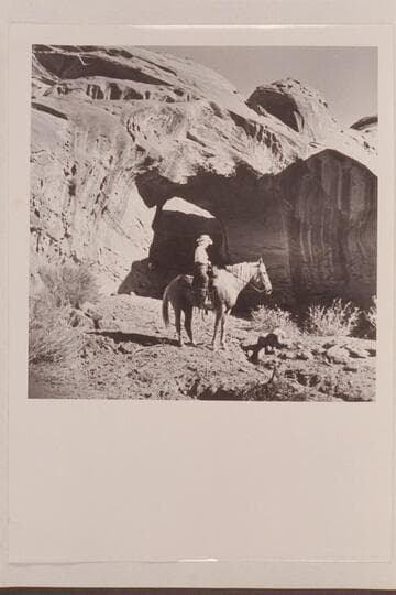 Nancy Daly sits her horse in front of the natural bridge in a side canyon of Navajo Canyon, Arizona.  The bridge may have been a discovery on 1954, Sep. 26 when this photo was taken Masland suggests naming the bridge White-hat Bridge