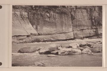 Undercut cliff at lower end of Triplet Rapid.  A. K. Reynolds running the "Lodore" in the low water