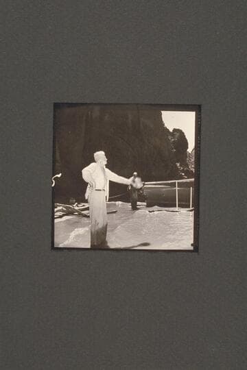 Joe Desloge carries on various activities during the repair of the "Cactus" below Tuna Creek Rapid.  Here he waves directions while Rod Sanderson watches