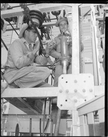 Electrical workers working with cable in vault and racks