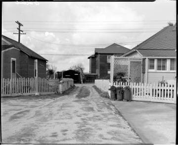 Looking down driveway beside house to street along