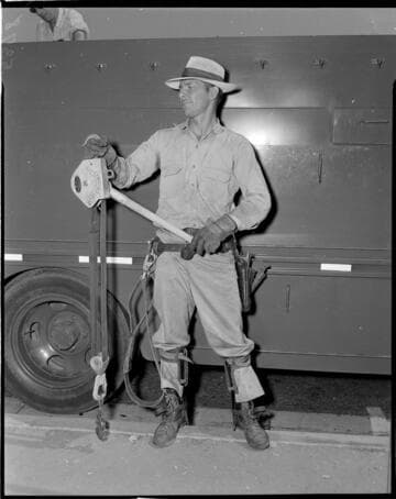 Lineman with Hi Line Hoist standing by line truck