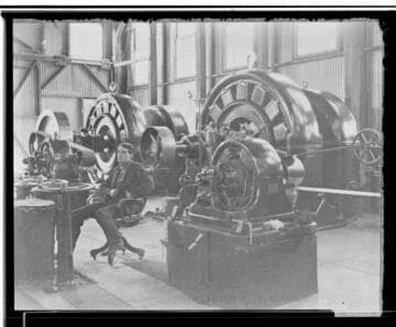 An interior view of Kaweah #1 Power House showing the operator sitting in front of the generators