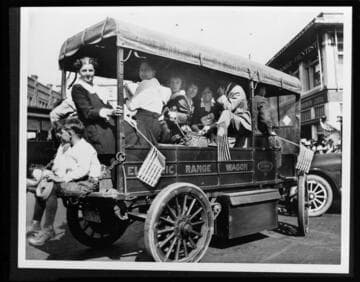 Electric Range Delivery Wagon with ladies waving American flags