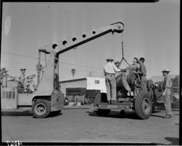 Loading conductor spools onto trailer with small crane