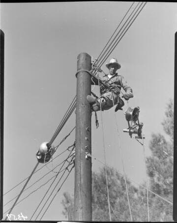 Line man working on top of pole