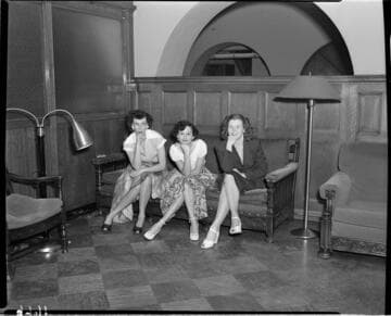Three young ladies seated in lobby with hands resting their chins