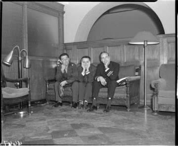 Three men seated in lobby