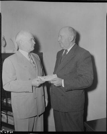 Man handing check to another man