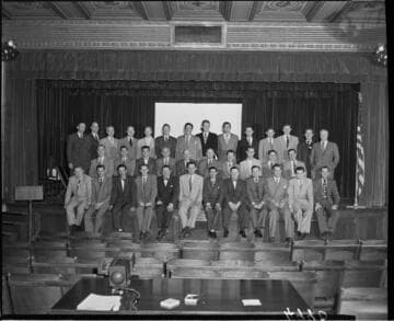 Group of men in suits on stage at Edison Auditorium