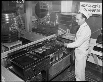Man cooking burgers and fries at a hamburger stand