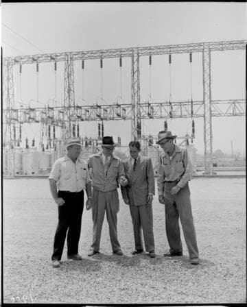 Four men standing in front of substation dead end