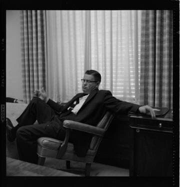 Three men seated in an executive office