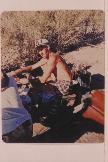 Brian Rowlands grinds coffee at camp at Mile 70