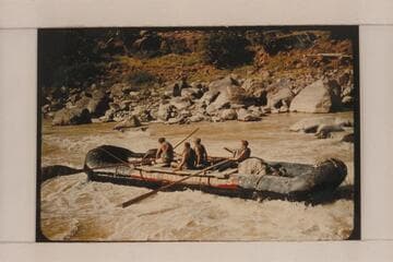 A boloney boat of the Hatch collection driving toward a rock in Hells Half Mile.  Jack Collier, oarsman at left; Dale; passengers are Bill McLand and Ed Richardson