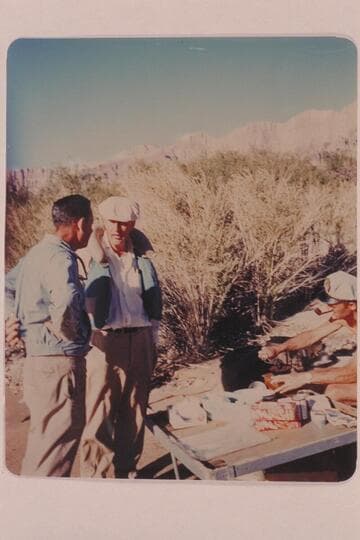 John Schulz passes the word to Chuck Richey, Brian Rowlands grinds coffee at right; Mile 70