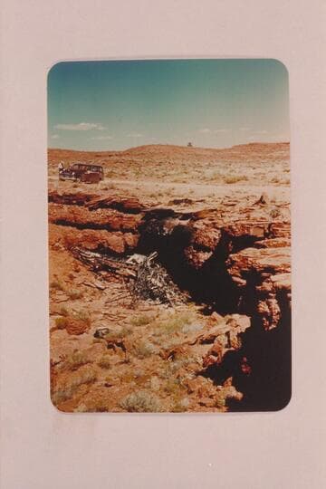 The wreck of the Nevills plane immediately after the crash.  The plane struck the ledge a few feet below the top and was consumed by fire.  Norm and Doris died in the wreckage.  The location is near Mexican Hat on the San Juan River