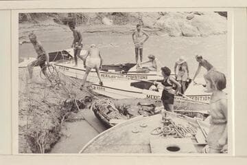 The combined Wright-Rigg parties landing at Spencer Creek, Mile 246.  Elgin Pierce jumps ashore with the painter of the inflated boat while Georgie White watches