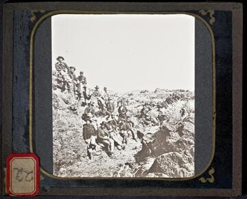 U.S. Army soldiers sitting among lava beds